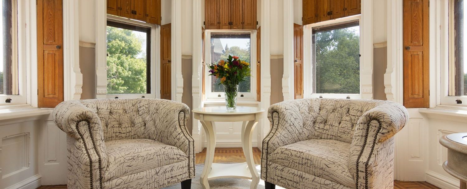 Belle fonte room sitting area with chairs and bay windows
