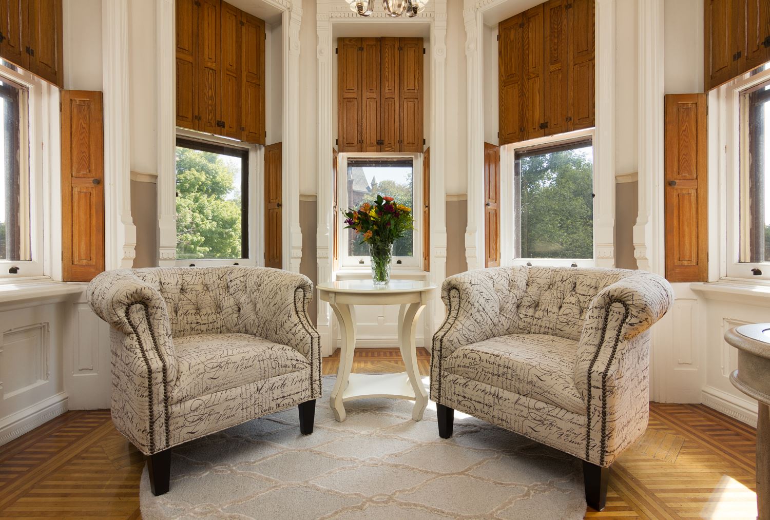 Belle fonte room sitting area with chairs and bay windows