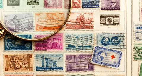 Magnifying glass with stamps in the background